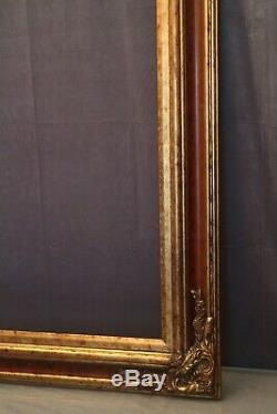 Très grand cadre en bois double patine acajou et or de style Louis XV